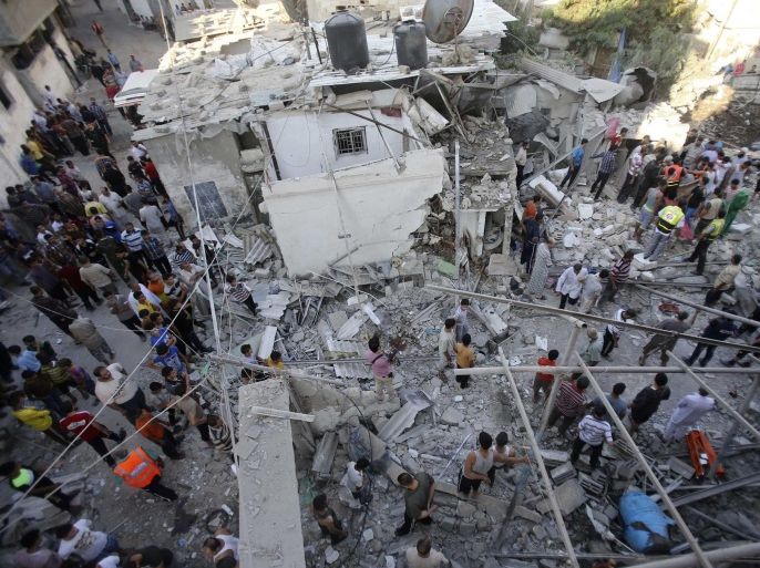 Palestinian rescue workers and onlookers stand on the rubble of a house, which witnesses said was destroyed by an Israeli air strike, as they search for casualties in Rafah, southern Gaza in this August 3, 2014 file photo. The July-August war in Gaza drew international condemnation for a number of reasons, but one episode proved more deadly than any other: an Israeli air and artillery bombardment on Aug. 1 that killed 150 people in a matter of hours.The events unfolded just as a three-day ceasefire was supposed to come into force. Hamas militants emerged from a tunnel inside Gaza and ambushed three Israeli soldiers, killing two of them and seizing the third.To rescue the soldier - dead or alive - and ensure Hamas could not use him as a hostage, the Israeli army invoked what is known as the "Hannibal directive", an order compelling units to do everything they can to recover an abducted comrade.What ensued was a furious assault on a confined area on the eastern edge of Rafah, the largest city in southern Gaza. To match Insight: MIDEAST-GAZA/WARCRIME REUTERS/Ibraheem Abu Mustafa/Files (GAZA - Tags: POLITICS CIVIL UNREST CONFLICT)