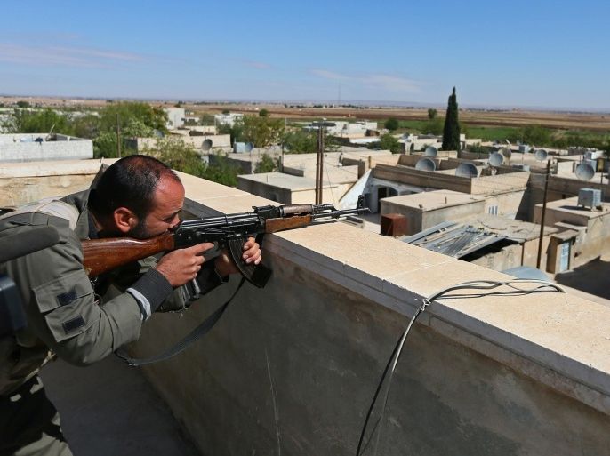 ALLEPPO, SYRIA - SEPTEMBER 30: A member of Kurdish armed group takes a position on the roof of a house during the clashes with Islamic State of Iraq and the Levant around Ayn Al Arab city of Aleppo in northern Syria on September 30, 2014.