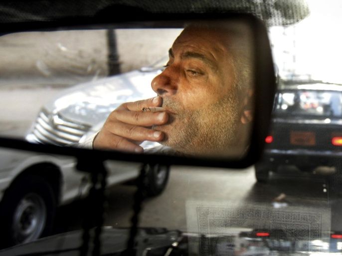 FILE - In this Thursday, April 26, 2007 file photo, Said Ali, 50, who said he has been a taxi driver for 25 years, smokes a cigarette while driving his cab in downtown Cairo, Egypt. On Sunday, July 6, 2014, Egypt’s President Abdel-Fattah el-Sissi, decreed new sales tax on cigarettes by up to 50 percent and on beer by 200 percent, the latest decision in a series of steep price hikes that aim to ease the country’s staggering budget deficit. Estimates put the number of smokers in Egypt between 17 to 21 percent of the adult population. (AP Photo/Ben Curtis, File)