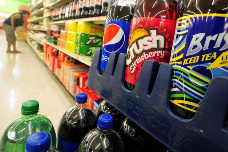 A woman shops for food items near a display of bottes of soda at a superrmarket in Rosemead, California on June 18, 2014, a day after a bill in California that would require soft drinks to have health warning labels failed to clear a key committee. Under the measure, sugary drinks sold in the most populous US state would have had to carry a label with a warning that sugar contributes to obesity, diabetes and tooth decay and the legislation, which would have been the first of its kind in the United States, passed the state Senate in May, but on it failed to win enough votes in the health commission of the California State Assembly on June 17, the Los Angeles Times reported. AFP PHOTO/Frederic J. BROWN
