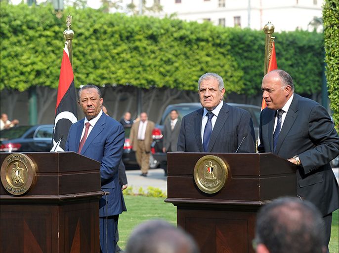 Egyptian Foreign Minister Sameh Shoukri (R) and Prime Minister Ibrahim Mahlab (2nd-R) take part in a press conference with Libyan Prime Minister Abdullah al-Thinni (L) in Cairo on October 8, 2014. AFP PHOTO / STR