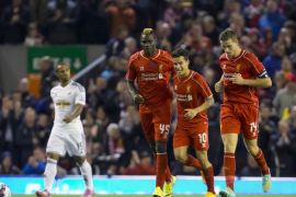 Liverpool's Mario Balotelli, centre left, celebrates with teammates after scoring against Swansea during the English League Cup soccer match between Liverpool and Swansea at Anfield Stadium, Liverpool, England, Tuesday Oct. 28, 2014. (AP Photo/Jon Super)