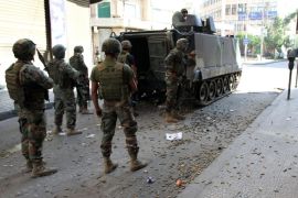 Lebanese army soldiers stand beside an armored vehicle with spent bullet casings littering the ground during clashes with Islamic militants, in the northern port city of Tripoli, Lebanon, Saturday, Oct. 25, 2014. Lebanese troops battled Islamic militants in Tripoli for a second day Saturday, with at least one person killed and a dozen people wounded in the clashes, the Lebanese army and state media said. (AP Photo)