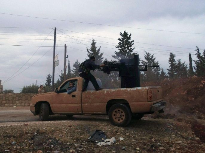 A rebel fighter fires a weapon mounted on a pick-up truck during what the rebels said was an offensive against forces loyal to Syria's President Bashar al-Assad around Handarat area, north of Aleppo in an attempt to regain control of the area October 11, 2014. Picture taken October 11, 2014. REUTERS/Abdalghne Karoof (SYRIA - Tags: POLITICS CIVIL UNREST)