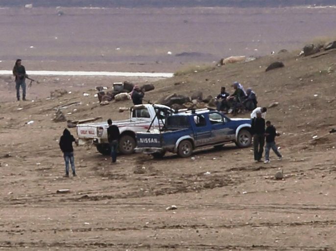 A group of fighters from the Syrian Kurdish People's Defence Units (YPG) stand by an armed truck near the town of Kobane, Syria, taken from the Turkish side of the Syrian Turkish border near Suruc district, Sanliurfa, Turkey, 17 October 2014. According to reports YPG fighters have made gains against IS militants in their defence of the besieged town of Kobane, aided by over 50 airstrikes around the town carried out by the international anti-IS coalition which according to the Pentagon have killed hundreds of IS militants in the operation now named Inherent Resolve.