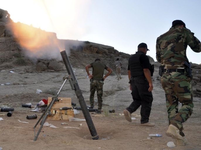 Members of Iraqi security forces and Shiite fighters fire a mortar during clashes with militants of the Islamic State, in Diyala province north of Baghdad October 5, 2014. Picture taken October 5, 2014. REUTERS/Stringer (IRAQ - Tags - Tags: CIVIL UNREST POLITICS MILITARY)