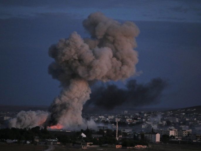 Thick smoke from an airstrike by the US-led coalition rises in Kobani, Syria, during fighting between Syrian Kurds and the militants of Islamic State group, as seen from a hilltop on the outskirts of Suruc, at the Turkey-Syria border, Monday, Oct. 20, 2014. Kobani, also known as Ayn Arab, and its surrounding areas, has been under assault by extremists of the Islamic State group since mid-September and is being defended by Kurdish fighters. (AP Photo/Lefteris Pitarakis)