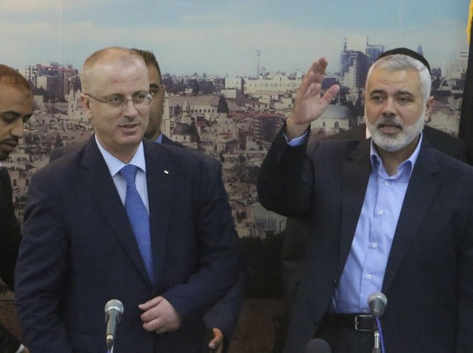 Senior Hamas leader Ismail Haniyeh (R) waves as he hosts Palestinian Prime Minister Rami Hamdallah at his house in Gaza City October 9, 2014. Hamdallah arrived in the Hamas-dominated Gaza Strip on Thursday and convened the first meeting of a unity government there since a brief civil war in 2007 between Hamas and forces loyal to the Fatah party. REUTERS/Ibraheem Abu Mustafa (GAZA - Tags: POLITICS CIVIL UNREST)