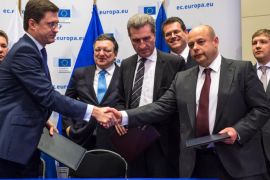 EU Commissioner for Energy Guenther Oettinger, center, Russian Energy Minister Alexander Novak , left, and Ukrainian Energy Minister Yuriy Prodan shake hands after they signed an agreement that guarantees Russian gas will continue to flow to Ukraine and, by extension, parts of the EU this winter as EU Commission President Jose Manuel Barroso, 2nd left back, Gazprom CEO Alexey Miller, left back, EU Commissioner for Inter-Institutional Relations and Administration Maros Sefcovic, 2nd righ back, and Naftogaz CEO Andriy Kobolev look on, at the European Commission headquarters in Brussels, Thursday, Oct. 30, 2014. (AP Photo/Geert Vanden Wijngaert)