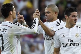 Real Madrid's Portuguese forward Cristiano Ronaldo (L) celebrates with Real Madrid's Portuguese defender Pepe (C) next to Real Madrid's Colombian midfielder James Rodriguez (R) after the Spanish league "Clasico" football match Real Madrid CF vs FC Barcelona at the Santiago Bernabeu stadium in Madrid on October 25, 2014. Real Madrid won the match 3-1. AFP PHOTO / GERARD JULIEN