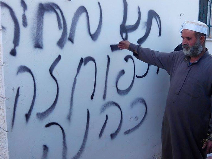 ‪فلسطيني يشير إلى شعارات المعتدين‬ (الجزيرة نت)