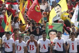 Kurdish protesters wear shirts forming the word 'Kobani' as others wave Lebanese and Kurdish flags and carry the image of Abdullah Ocalan, jailed leader of the Kurdistan Workers' Party (PKK), during a demonstration against Islamic State (IS) insurgent attacks on the Syrian Kurdish town of Kobani, in Beirut in this October 12, 2014 file photo. As southeast Turkey's Kurds rioted last week in fury at Ankara's refusal to rescue the Syrian Kurdish town of Kobani from advancing Islamists, it was to Ocalan that Prime Minister Ahmet Davutoglu turned for help. Sitting in jail on the windswept island where he has spent the last 15 years, Ocalan wields more power as a peacemaker than he ever did as the guerrilla commander leading a Kurdish insurgency in which 40,000 people have died. To match story TURKEY-KURDS/OCALAN. REUTERS/Mohamed Azakir/Files (LEBANON - Tags: POLITICS CIVIL UNREST)