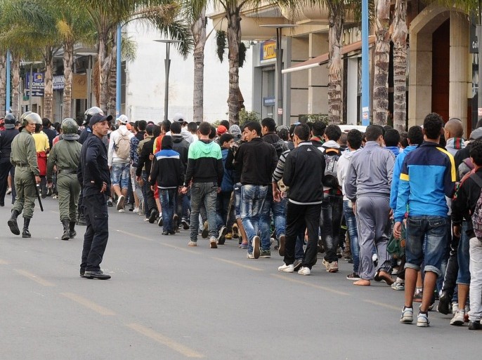 Supporters of Rabat FAR football club arrive at the Mohamed V complex, as police looks on, to attend the football match between Casablanca RCA and Rabat FAR of on April 11, 2013 in Casablanca. 200 people were arrested during clashes on the fringe of the football match during which shops and buses have been damaged.