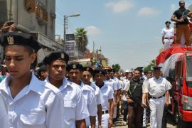 Members of the Egyptian security forces attend the funeral for a police officer who was killed by unknown gunmen Friday, while marching on a street in Abou Khalifa in the Ismailia governorate, 120 kilometers (75 miles) east of Cairo, Egypt, Saturday, July 19, 2014. According to officials, the officer was shot dead by unknown gunmen in el-Arish, a city in the Sinai, where Egypt is fighting Islamic extremists. (AP Photo/Khaled Kandil)