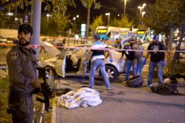 An Israeli policeman stands on guard near the scene after a car rammed a group of pedestrians at the Ammunition Hill tram stop, which lies on the seamline between west and occupied east Jerusalem, injuring nine on October 22, 2014. Israeli police shot and wounded the driver of a car in a suspect
