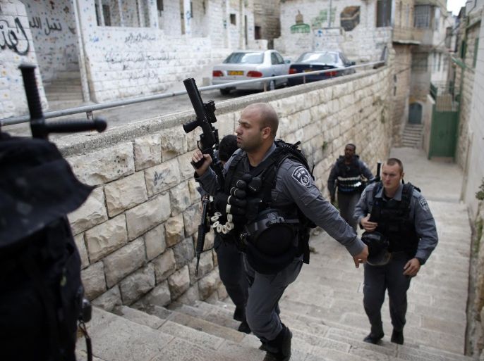 Israeli police officers patrol near a house purchased by Jews (back, with mural on the wall) in the mostly Arab neighbourhood of Silwan in east Jerusalem October 20, 2014. Israeli guards quietly occupied two purchased residential buildings in the Palestinian district of East Jerusalem on Monday, expanding a Jewish settler project in defiance of U.S. criticism. REUTERS/Ronen Zvulun (JERUSALEM - Tags: POLITICS REAL ESTATE)