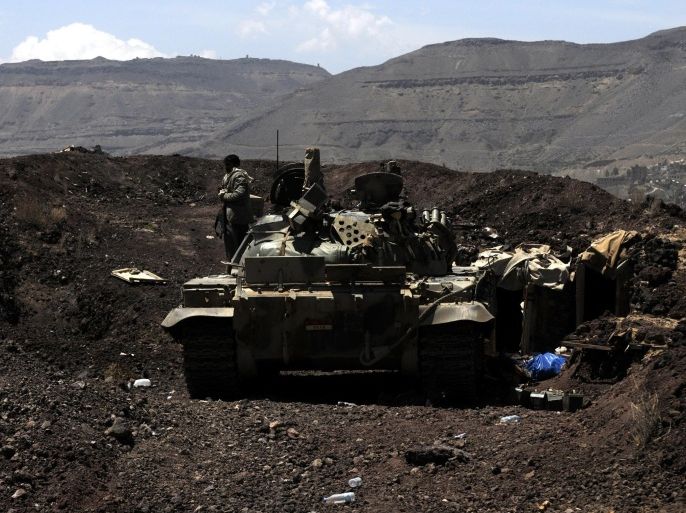 SANAA, YEMEN - SEPTEMBER 22: A Houthi militant waits near a seized tank after they captured the headquarters of the Sixth Military Zone following rough clashes with Yemeni government forces in northern Sanaa, Yemen on September 22, 2014. Photo by Mohammed Hamoud/Anadolu Agency/Getty Images