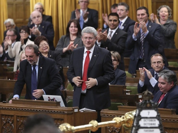 Canada's Prime Minister Stephen Harper stands to vote in favour of a government motion to participate in U.S.-led air strikes against Islamic State militants operating in Iraq, in the House of Commons on Parliament Hill in Ottawa October 7, 2014. The motion passed 157 to 134. REUTERS/Chris Wattie (CANADA - Tags: POLITICS MILITARY TPX IMAGES OF THE DAY)