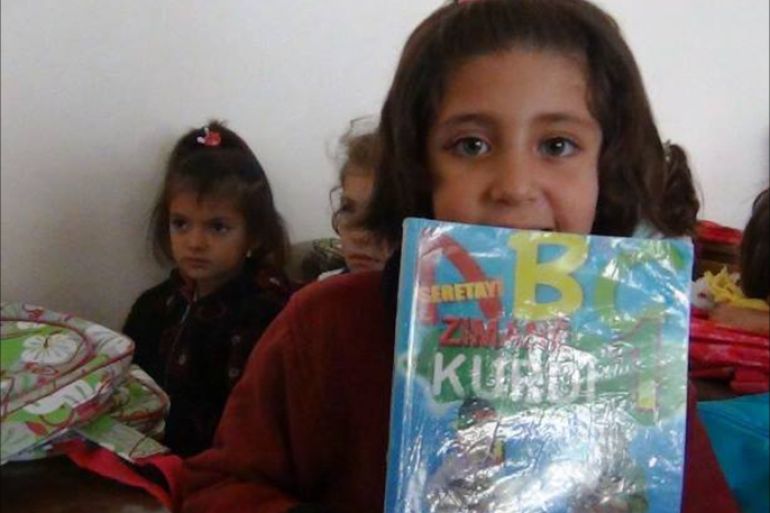 طلاب في مدارس الحسكة السورية يحملون كتاب تعليم اللغة الكردية