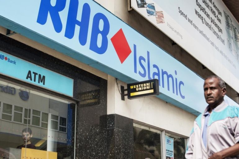 A pedestrian walks past an RHB Islamic Bank Bhd. branch in Kuala Lumpur, Malaysia, on Friday, Oct. 10, 2014. CIMB Group Holdings Bhd., Malaysia's second-biggest lender, and RHB Capital Bhd. agreed to a three-way merger with Malaysia Building Society Bhd. valued at 72.5 billion ringgit ($22.3 billion) that creates the nation's largest bank by assets.