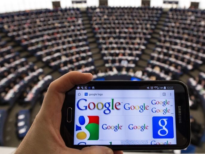A mobile phone displaying the Google logo is held as members of the European Parliament vote during the plenary session in the European Parliament in Strasbourg, France, 27 November 2014. MEPs will vote on a resolution on consumer rights on the Internet in Europe.