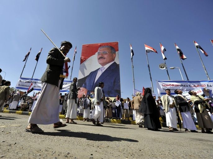 Supporters of Yemen's ex-president Ali Abdullah Saleh gather next to a huge poster of Saleh to protest against foreign interferences, in Sana'a, Yemen, 07 November 2014. Reports state thousands of supporters of former Yemeni president Ali Abdullah Saleh gathered in center Sana'a to protest against a US-backed move of the UN Security Council to impose a travel ban and assets freeze on Saleh due to his involvement in obstructing the countrys transitional process. Recently, he has been accused of colluding with Shiite Houthi fighters in their military takeover of much of Yemen.