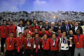 Palestinian president Mahmud Abbas (C) receives, in his office in the West Bank city of Ramallah on June 1, 2014, the Palestinian national football team which won the AFC Challenge Cup. Palestine qualified for their maiden Asian Cup appearance with a 1-0 win over injury-hit Philippines in the final of the AFC Challenge Cup in Maldives. AFP PHOTO/ABBAS MOMANI