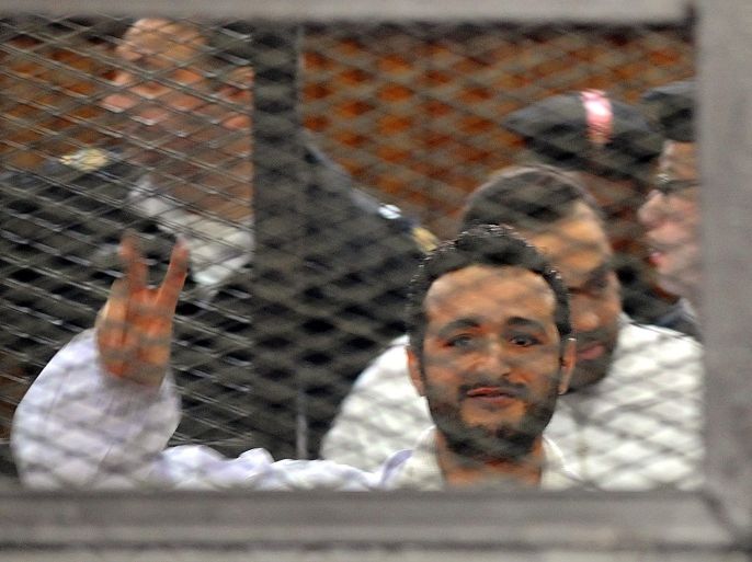 (FILE) A file photo dated 22 December 2013 shows Egyptian activist Ahmed Douma flashing victory sign behind dock bars during his trial in Cairo, Egypt. A Cairo court on 07 April 2014 rejected an appeal by three Egyptian activists against a three-year jail sentence for holding an unauthorized demonstration. Ahmed Maher, founder of the April 6 Youth Movement which played a key role in the 2011 uprising against long-time ruler Hosni Mubarak, and two other activists, Ahmed Douma and Mohamed Adel, were convicted in December of organizing an unauthorized protest and attacking police. EPA/FOAD GARNOSY ELMAGD / ALMASRY AL BEST QUALITY AVAILABLE - EGYPT OUT