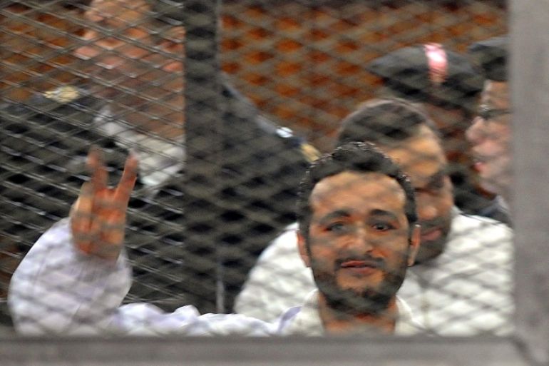 (FILE) A file photo dated 22 December 2013 shows Egyptian activist Ahmed Douma flashing victory sign behind dock bars during his trial in Cairo, Egypt. A Cairo court on 07 April 2014 rejected an appeal by three Egyptian activists against a three-year jail sentence for holding an unauthorized demonstration. Ahmed Maher, founder of the April 6 Youth Movement which played a key role in the 2011 uprising against long-time ruler Hosni Mubarak, and two other activists, Ahmed Douma and Mohamed Adel, were convicted in December of organizing an unauthorized protest and attacking police. EPA/FOAD GARNOSY ELMAGD / ALMASRY AL BEST QUALITY AVAILABLE - EGYPT OUT