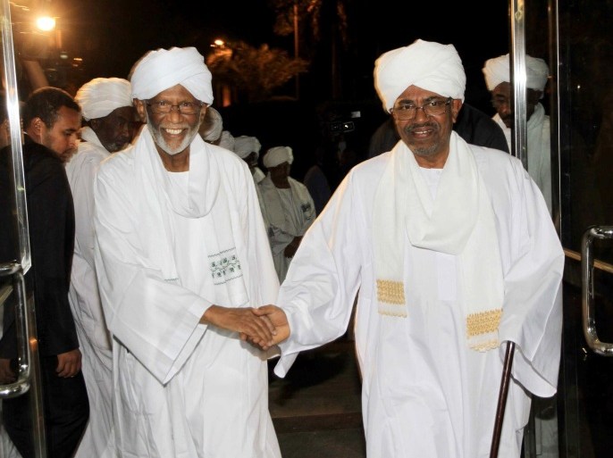 Sudan's President Omar al-Bashir (R) shakes hands with breakaway Islamist Hassan al-Turabi as they arrive for a meeting on March 14, 2014 at the presidential guest house in the capital Khartoum. Bashir officially met Turabi for the first time in 14 years, as the government reaches out to opponents after calls for reform. AFP PHOTO / EBRAHIM HAMID
