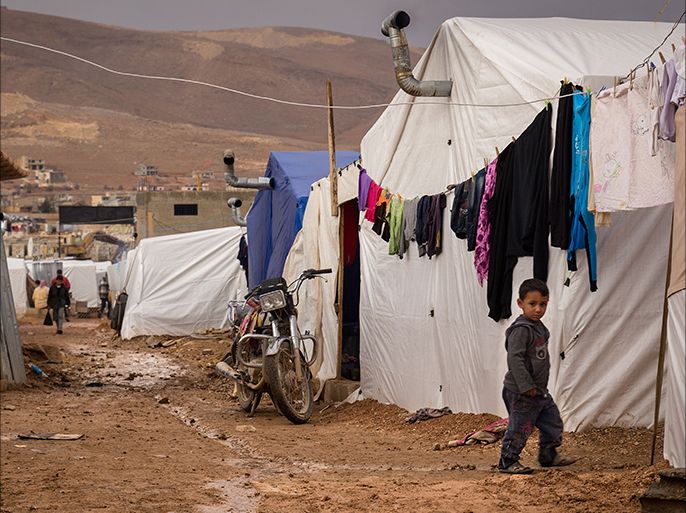 A young Syrian refugee walks past tents at the Al-Nihaya camp in the eastern Lebanese town of Arsal on October 23, 2014. With more than 1.1 million Syrian refugees, Lebanon has the most refugees per capita in the world, and the influx has created some resentment in a country of four million already facing economic and political challenges. AFP