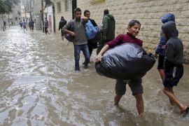 Palestinians carry their belongings as they leave their flooded family house during heavy rain in Gaza City, northern Gaza Strip, Thursday, Nov. 27, 2014. Hundreds of houses were flooded following a rain storm in several area in Gaza. (AP Photo/Adel Hana)