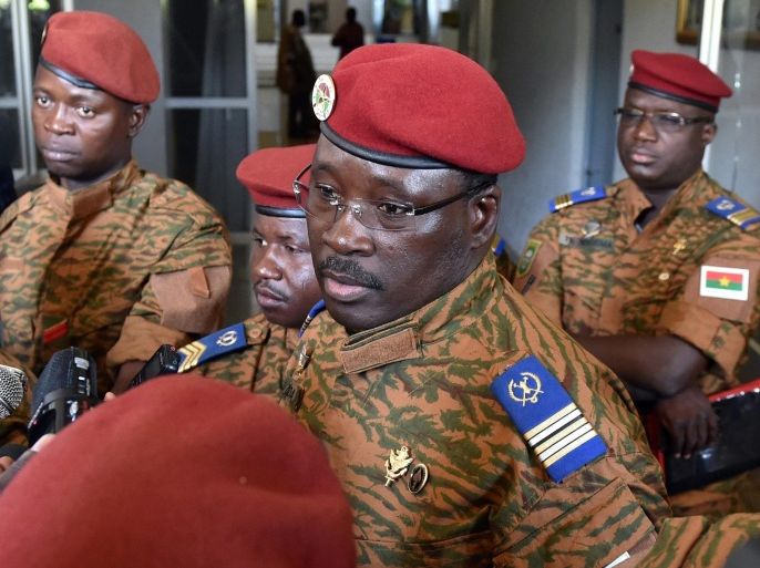 Burkinese Lieutenant-Colonel Isaac Zida, (C), named by Burkina Faso's army as interim leader following the ousting of president Blaise Compaore, speaks to journalists after a meeting gathering soldiers and diplomats on November 3, 2014 in Ouagadougou. The head of Burkina Faso's military regime promised to deliver a 'consensus' leader in talks on installing a unity government in the west African nation following a violent crackdown on protesters. AFP PHOTO / ISSOUF SANOGO
