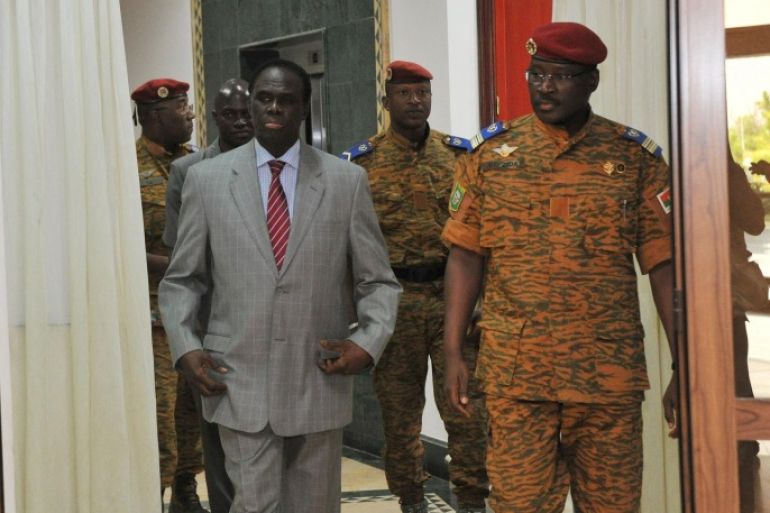 Interim president Michel Kafando (l) walks with Lieutenant Colonel Isaac Zida obn Novenber 19, 2014 at the presidential palace in Ouagadougou. Lieutenant Colonel Zida, who took power after the fall of Burkina Faso president Blaise Compaore was Wednesday named prime minister in the west African country's interim government. AFP PHOTO / SIA KAMBOU