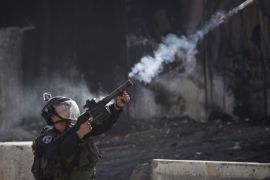 An Israeli border policeman fires a tear gas canister during clashes with protesters opposing Israeli restrictions on the Al-Aqsa Mosque in Jerusalem, at the Qalandia checkpoint near the West Bank city of Ramallah, Friday, Nov. 21, 2014.(AP Photo/Majdi Mohammed)