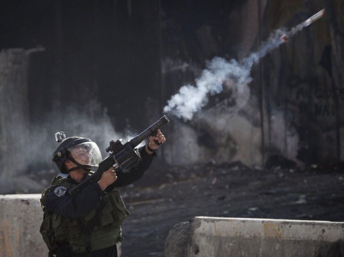 An Israeli border policeman fires a tear gas canister during clashes with protesters opposing Israeli restrictions on the Al-Aqsa Mosque in Jerusalem, at the Qalandia checkpoint near the West Bank city of Ramallah, Friday, Nov. 21, 2014.(AP Photo/Majdi Mohammed)