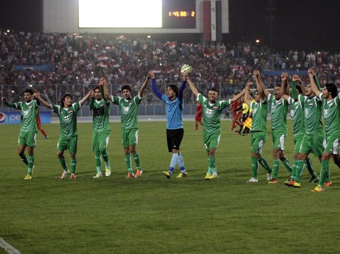 Iraq's national football team celebrates after an international friendly soccer match between Iraq and Syria in Baghdad, Tuesday, March 26, 2013. Tens of thousands of Iraqi football fans packed a stadium in eastern Baghdad on Tuesday to watch the country's first international match at home for 18 months, a 2-1 victory over Syria. (AP Photo/ Khalid Mohammed)
