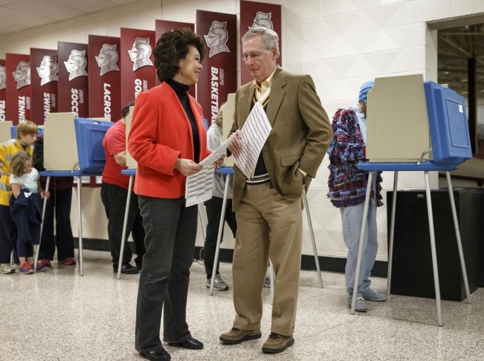 Senate Minority Leader Mitch McConnell of Ky., and his wife, former Labor Secretary Elaine Chao, wait for an open booth to cast their ballots in the midterm election at the voting precinct at Bellarmine University in Louisville, Ky., Tuesday, Nov. 4, 2014. The Kentucky Senate race, with McConnell, a 30-year incumbent, facing a spirited challenge from Democrat Alison Lundergan Grimes, has been among the most combative and closely watched contests that could shift the balance of power in Congress. (AP Photo/J. Scott Applewhite)