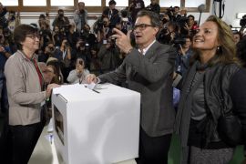 The president of Catalonia's regional government, Artur Mas (C), casts his ballot on November 9, 2014 next to his wife Helena Rakosnik (R) in Barcelona to vote in a symbolic ballot on whether to break away as an independent state, defying fierce challenges by the Spanish government. One of Spain's richest but most indebted regions, Catalonia's long-standing yearning for greater autonomy has swelled in recent years of economic hardship, sharpened by resistance from Madrid. AFP PHOTO / LLUIS GENE