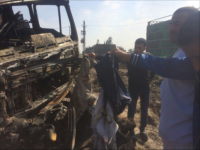 ‪الأهالي يفحصون بقايا ملابس الضحايا الذين تفحمت جثثهم‬ (الجزيرة نت)