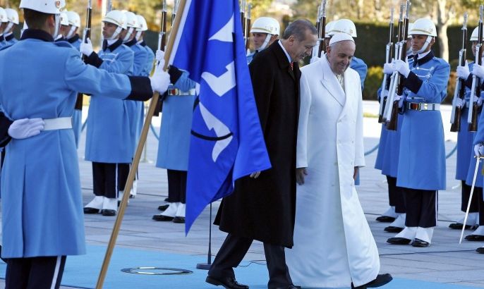 Pope Francis and Turkey's President Tayyip Erdogan walk in front of honor guard at the presidential palace in Ankara November 28, 2014. Pope Francis begins a visit to Turkey with the delicate mission of strengthening ties with Muslim leaders while condemning violence against Christians and other minorities in the Middle East. REUTERS/Tony Gentile (TURKEY - Tags: POLITICS RELIGION)