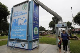 People leave a giant air purifier, which its inventor calls a "super tree", in Lima's district of Jesus Maria November 24, 2014. In Peru's notoriously polluted capital Lima, local inventor Jorge Gutierrez, a retired naval engineer, is deploying the giant air purifiers that double as billboards to suck up carbon dioxide and dangerous levels of smog. Picture taken November 24, 2014. REUTERS/ Mariana Bazo (PERU - Tags: ENVIRONMENT POLITICS SOCIETY)