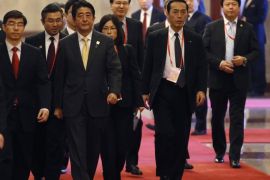 BEIJING, CHINA - NOVEMBER 10: Japan's Prime Minister Shinzo Abe (C) and his delegation walk along a carpet during a meeting with China's President Xi Jinping (not pictured), at the Great Hall of the People, on the sidelines of the Asia Pacific Economic Cooperation (APEC) meetings, November 10, 2014 in Beijing, China. APEC Economic Leaders' Meetings and APEC summit is being held at Beijing's outskirt Yanqi Lake.