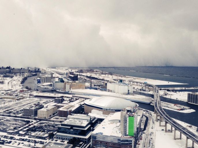 A band of storm clouds moves across Lake Erie and into Buffalo, N.Y., Tuesday, Nov. 18, 2014. Parts of New York measured the season's first big snowfall in feet, rather than inches, on Tuesday as 3 feet of lake-effect snow blanketed the Buffalo area and forced the closure of a 132-mile stretch of the state Thruway. (AP Photo/Gary Wiepert)