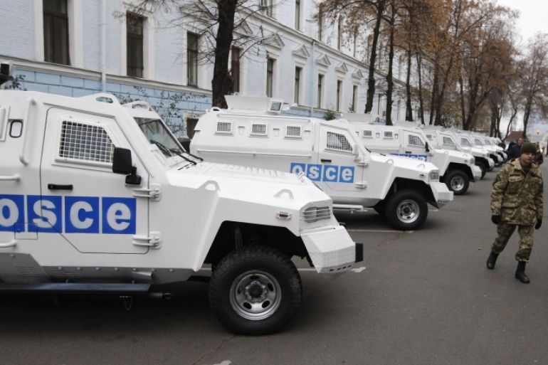 KIEV, UKRAINE - NOVEMBER 13: Ukrainian soldiers are seen near the armoured vehicles handed over to Organization for Security and Co-operation in Europe (OSCE) Special Monitoring Mission to Ukraine during the ceremony held at the Defense Ministry in Kiev, Ukranine, on November 13, 2014.