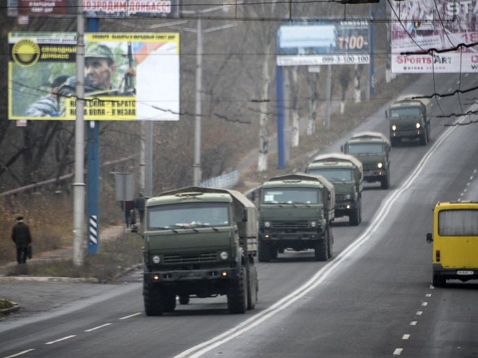 Unmarked military vehicles travel along a road outside the separatist rebel-held town Makiivka, 25 km (16 miles) from Donetsk, eastern Ukraine on Saturday, Nov. 8, 2014. AP reporters saw more than 80 military vehicles on the move Saturday in separatist-controlled areas, indicating intensified hostilities may lie ahead. (AP Photo/Mstyslav Chernov)