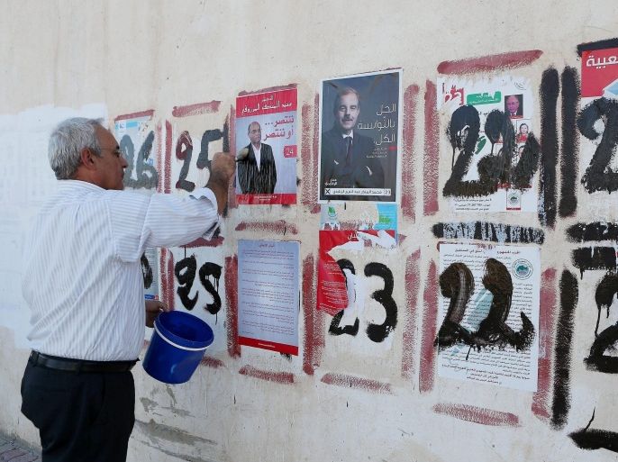 A Tunisian activist puts up an election poster of Tunisian President Moncef Marzouki in a Tunis suburb, Tunisia, 03 November 2014. The presidential election is scheduled to be held in Tunisia on 23 November 2014, with 26 men and one woman running for the post.