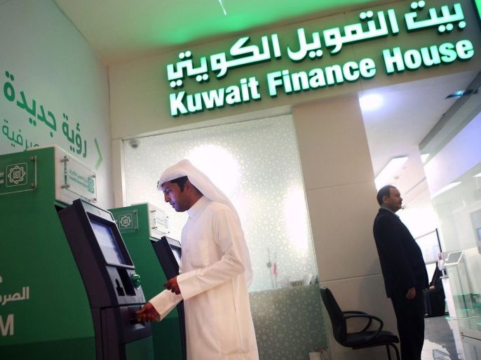 TO GO WITH AFP ECO STORY BY OMAR HASANA Kuwaiti man withdraws cash from an ATM outside a Kuwait Finance House branch inside the Avenues Mall, the largest shopping centre in Kuwait on November 19, 2014. The International Monetary Fund (IMF), the World Bank, and other global economic bodies estimate that the assets of Islamic financial institutions grew nine-fold to USD 1.8 trillion between 2003 and last year. AFP PHOTO/ YASSER AL-ZAYYAT