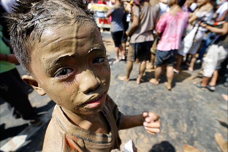 epa04479861 A Filipino boy with mud on his face joins a protest at Mendiola Bridge, near the Malacanang presidential palace in Manila, the Philippines, 07 November 2014. Protesters commemorated the calamity with a mud people denounces Philippine President Aquino III alleged neglect for the needs of victims of super typhoon Haiyan, who are until now suffering from the aftermath. One year after Haiyan left nearly 8,000 people dead or missing in the eastern Philippines, many survivors are still suffering from emotional distress despite being busy with physically rebuilding their lives. Over four million people were displaced when Haiyan destroyed or damaged almost everything in its path as it swept through the eastern and central Philippines on 08 November 2013. At least one million of these survivors were residents of coastal communities devastated by tidal surges as high as 10 meters, and are being prioritized for relocation. EPA/RITCHIE B. TONGO