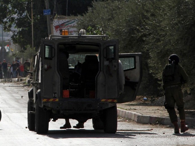 An armed Israeli soldier takes up position during clashes with Palestinian protesters in Bet Foril village, near the West Bank city of Nablus, 11 November 2014. According to media reports, Israeli soldiers have arrested the father and the three brothers of a Palestinian accused of stabbing to death an Israeli soldier in Tel Aviv, the official Palestinian Wafa news agency reported.